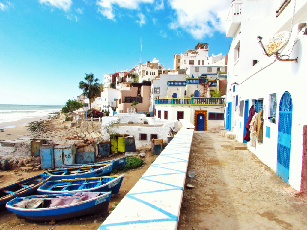 Playa marroquí con barcas de pescadores tradicionales y redes junto al mar